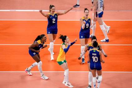 Jogadores do vôlei feminino do Brasil comemoram ponto se abraçando na quadra