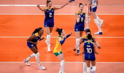 Jogadores do vôlei feminino do Brasil comemoram ponto se abraçando na quadra