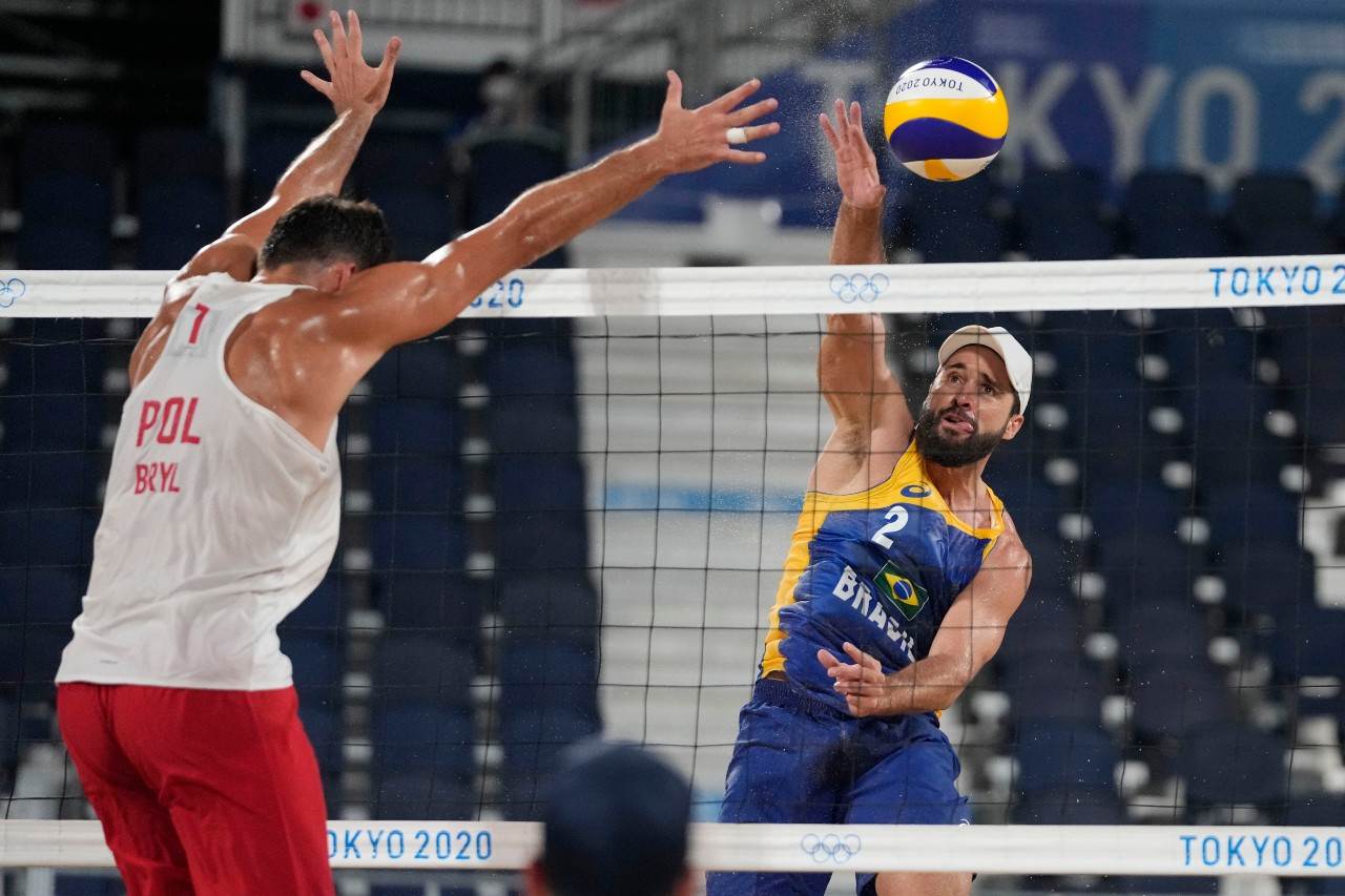 Bruno Schmidt, jogador de vôlei de praia, ataca bola contra polonês Michal Bryl