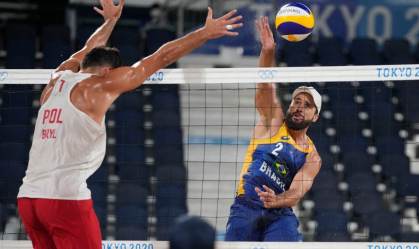 Bruno Schmidt, jogador de vôlei de praia, ataca bola contra polonês Michal Bryl