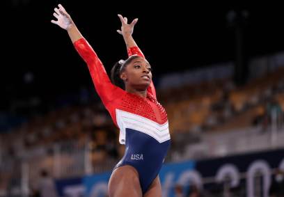Ginasta dos EUA Simone Biles com os braços para o alto após finalizar exercício