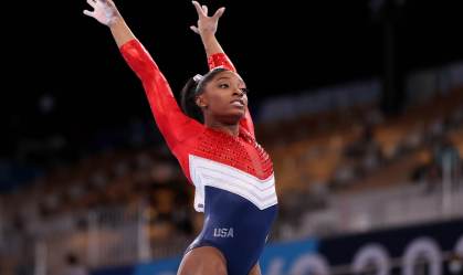 Ginasta dos EUA Simone Biles com os braços para o alto após finalizar exercício