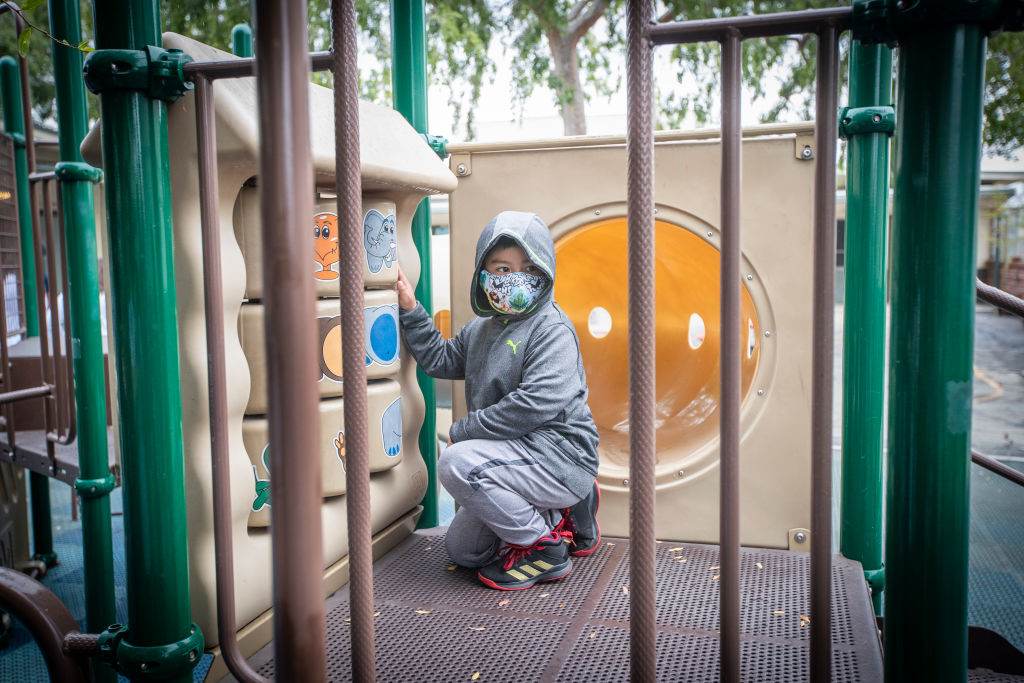Criança com máscara em parque de Los Angeles, EUA
