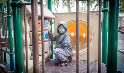 Criança com máscara em parque de Los Angeles, EUA