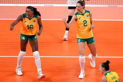 Jogadoras do Brasil vibram com punhos fechados em jogo de vôlei