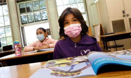 Criança usando máscara em escola dos Estados Unidos