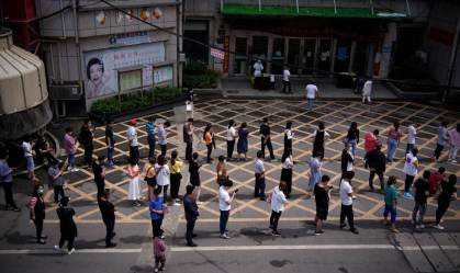 Moradores fazem fila para serem testados em Wuhan, na China