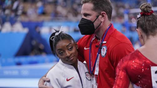 Técnico da ginástica norte-americana Laurent Landi abraça Simone Biles após ela desistir da final por equipes da ginástica artística das Olimpíadas 2020