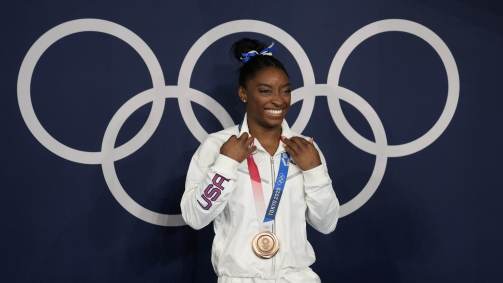 Simone Biles sorri ao posar com a medalha de bronze na final da trave da ginástica artística das Olimpíadas 2020