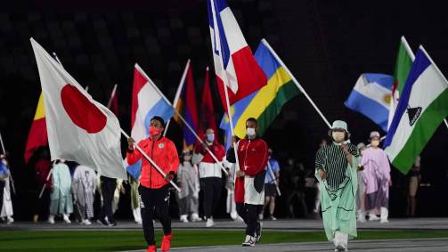 Kiyuna Ryo, do Japão, carrega a bandeira do país no fim das Olimpíadas 2020