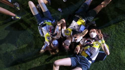 Atletas da austrália deitaram no gramado do estádio olímpico para tirar foto durante cerimônia