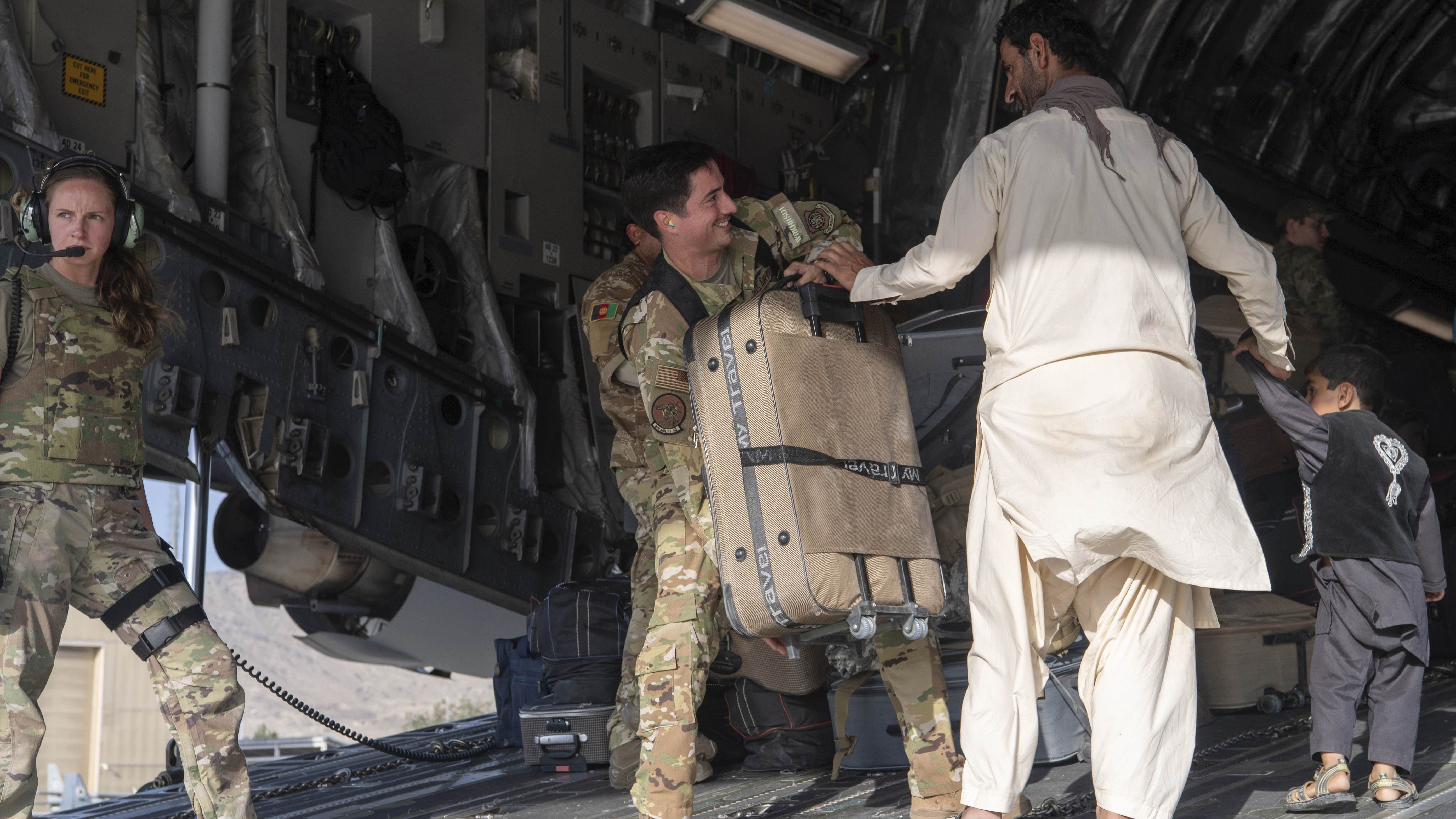 Soldado dos EUA ajuda afegão e seu filho a embarcarem em voo no aeroporto de Cabul / Sgt. Donald R. Allen - 24.ago.2021/U.S. Air Force via AP