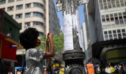 Mulher fotografa cartazes com oportunidades de emprego no centro de São Paulo 30/09/2020