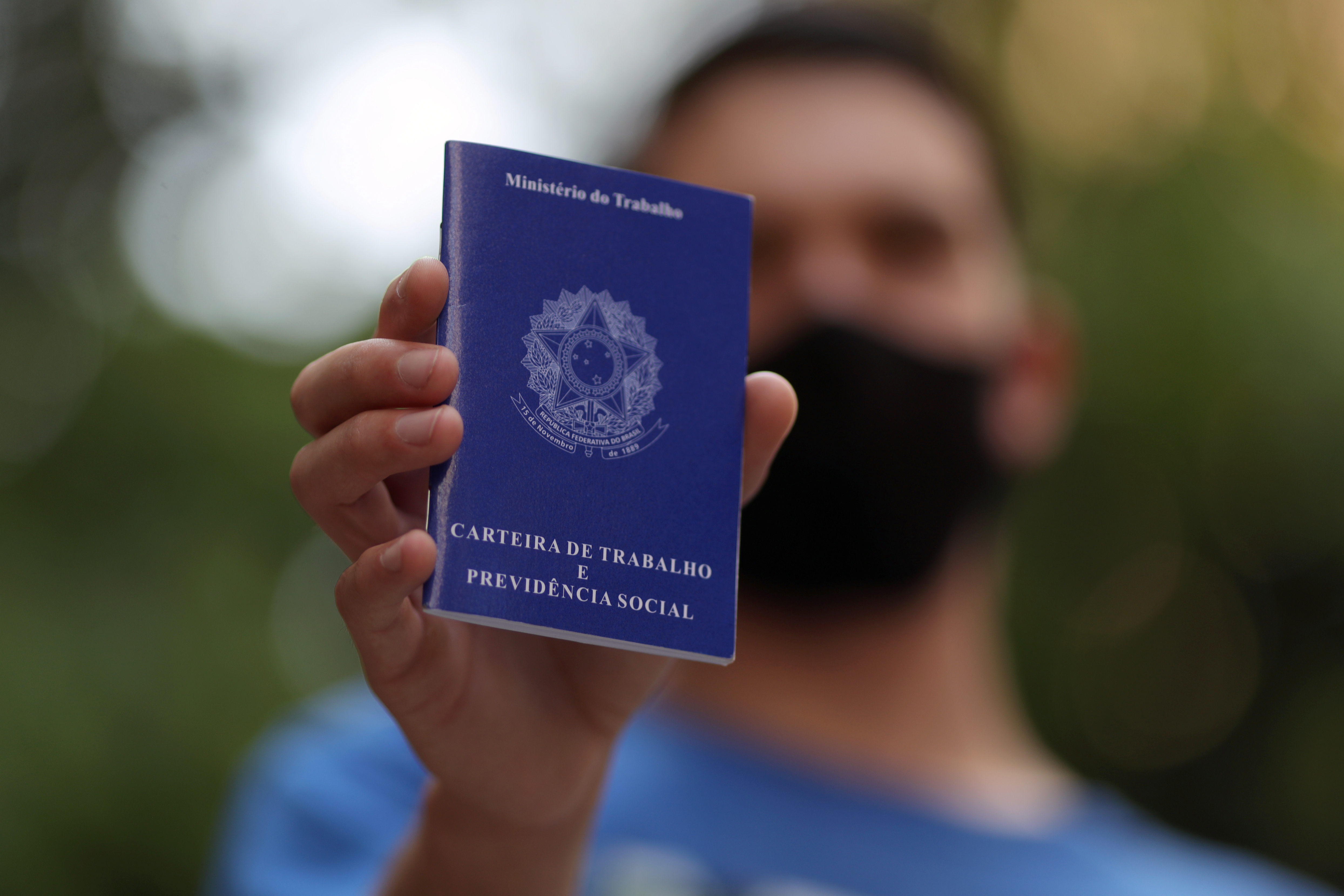 Homem mostra carteira de trabalho enquanto procura por vagas de emprego no centro de São Paulo