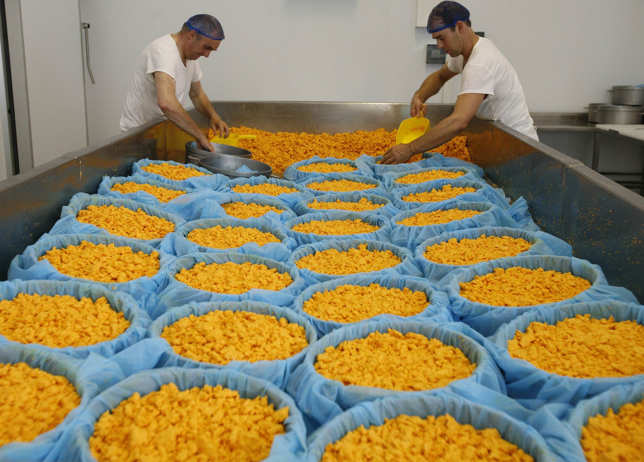 Homens trabalham na produção do queijo Leicester em Upton, Inglaterra