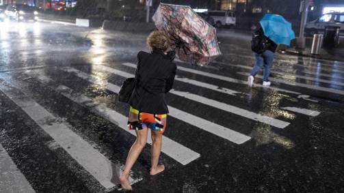 Pedestres tentam se proteger da chuva perto do Columbus Circle, em New York