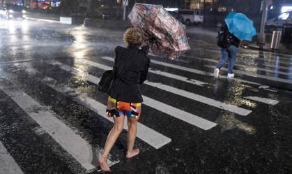 Pedestres tentam se proteger da chuva perto do Columbus Circle, em New York