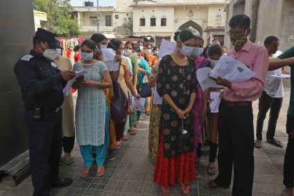 Fiscais conferem dados de candidatos no distrito de Jaipur, em Rajasthan, antes de teste para contratação de professores na Índia