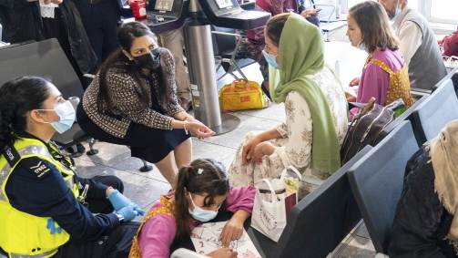 Priti Patel, secretária para Assuntos Internos do Reino Unido, conversa com refugiadas afegãs recebidas no Aeroporto de Londres