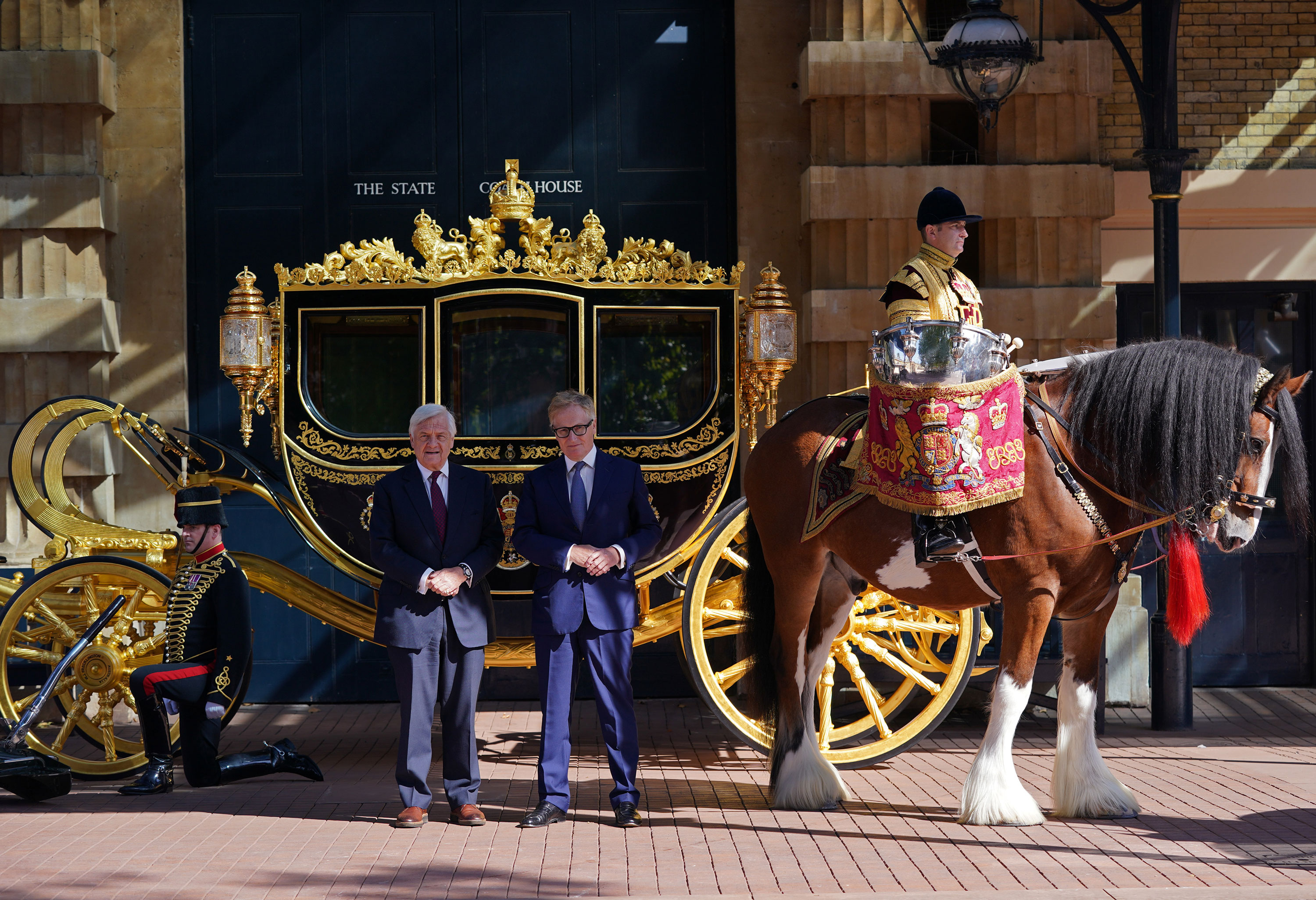 Simon Brooks-Ward, produtor e diretor (à direita), e Mike Rake, presidente do comitê consultivo do Jubileu de Platina, posam em frente ao Diamond Jubilee State Coach durante o lançamento para a imprensa da celebração / Yui Mok/PA Images/Getty Images