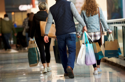 Consumidores carregam sacolas de mercadorias compradas