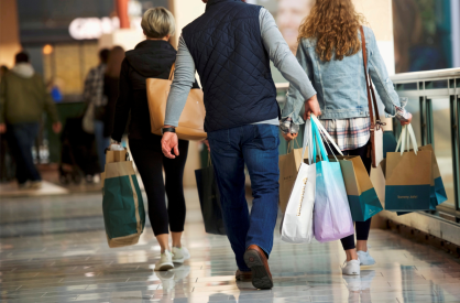 Consumidores carregam sacolas de mercadorias compradas