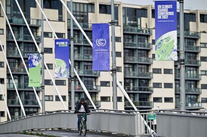 Homem pedala em frente a prédios onde acontecerá COP26