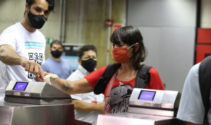Passageira é orientada durante embarque no Metrô de SP com bilhete usando QR Code