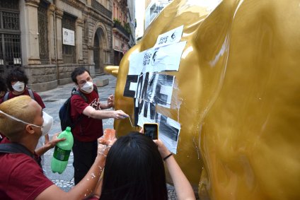 Manifestantes colam cartaz escrito &quot;Fome&quot; em escultura do Touro de Ouro, localizada diante da Bolsa de Valores de São Paulo (B3)