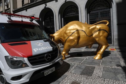 Viatura da Polícia Militar de São Paulo ao lado da escultura do &quot;Touro de Ouro&quot;, diante da B3, que amanheceu pichado