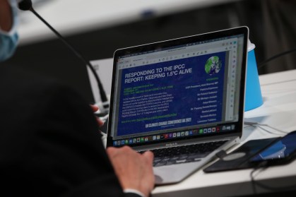 Participante da COP26 analisa material sobre o limite climático de 1,5 ºC