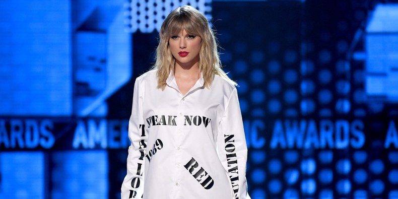 Taylor Swift usou uma camisa com o nome de todos os álbuns retidos pela antiga gravadora em apresentação no American Music Awards (AMA) em 2019, apresentação na qual ela alega ter sido impedida de tocar as canções / Getty Images