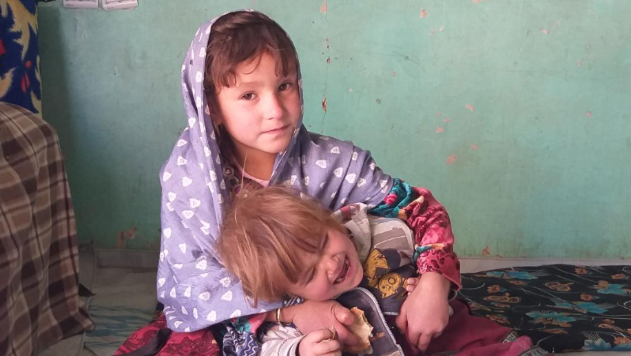 Zaiton, 4, brinca com o irmão na casa deles na província de Ghor, Afeganistão/Reprodução/CNN