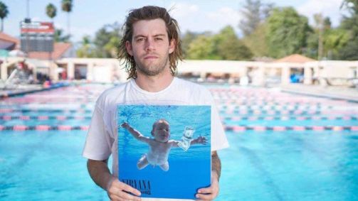 Spencer Elden, em imagem de 2016, segurando uma cópia de Nevermind