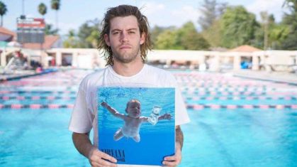 Spencer Elden, em imagem de 2016, segurando uma cópia de Nevermind