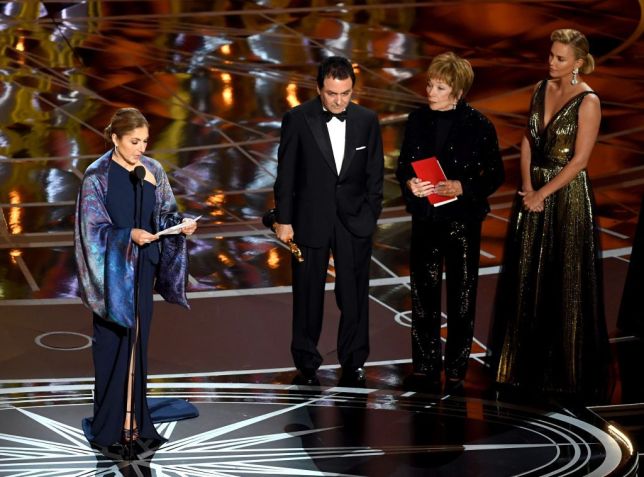 A astronauta Anousheh Ansari e o ex-cientista da NASA Firouz Naderi aceitam prêmio de Melhor Filme em Língua Estrangeira por "O Apartamento" em nome do diretor Asghar Farhadi / Getty Images