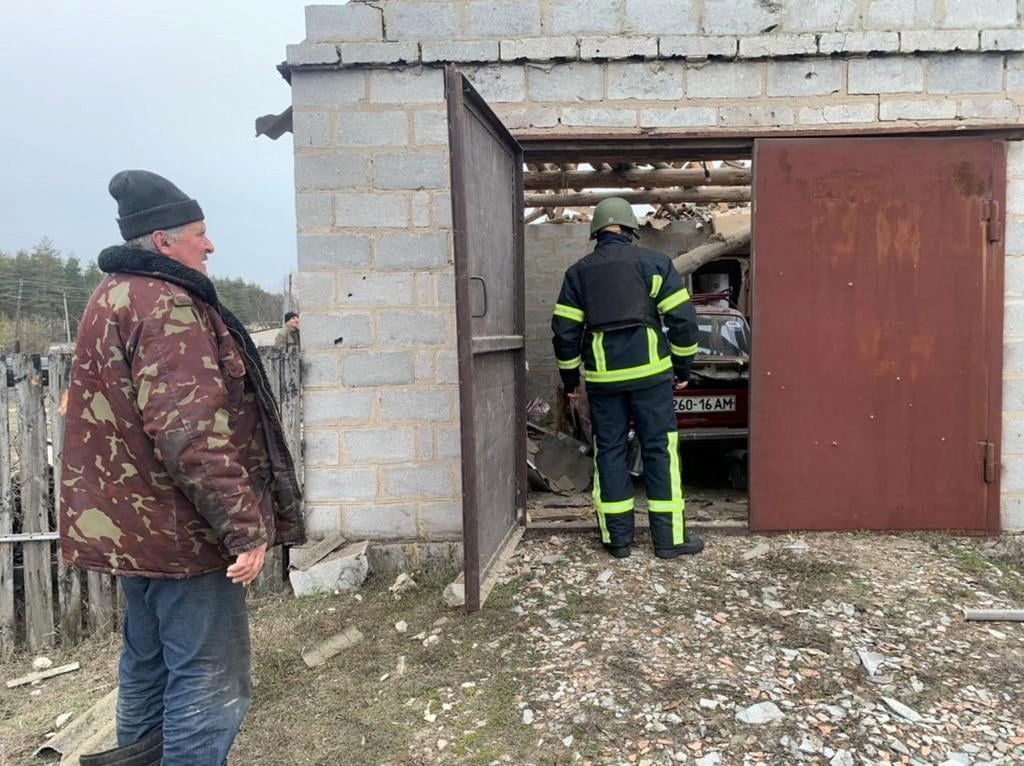 Membro de equipe de resgate inspeciona garagem danificada em Stanytsia Luhanska na região de Luhabsk, na Ucrânia