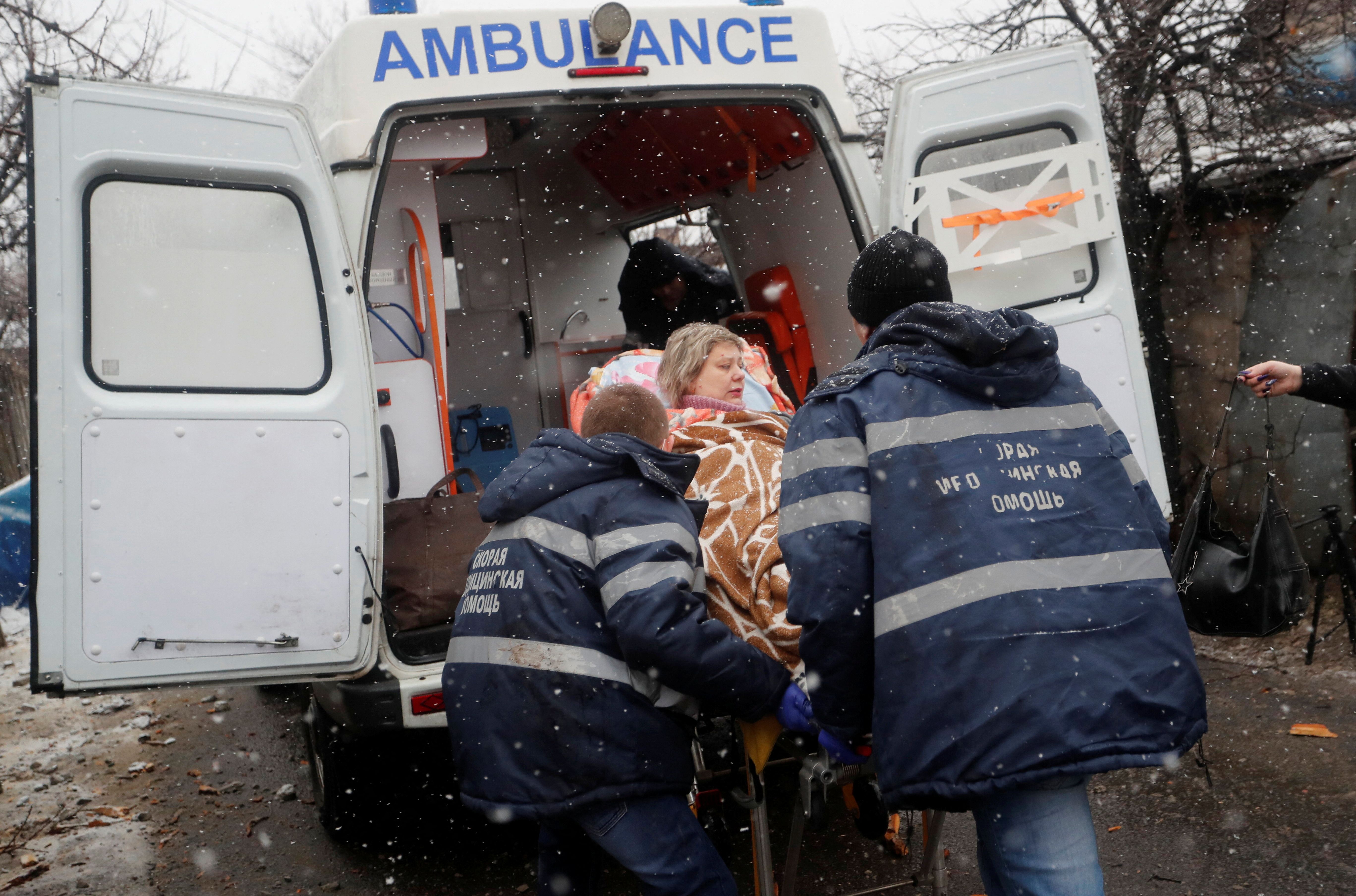 Especialistas médicos transportam mulher ferida em ataque em Donetsk, na Ucrânia (03/03/2022)