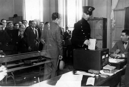 Eleitor insere voto em urna de metal na eleição de 1945