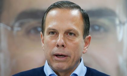 Governador de São Paulo, João Doria, em frente a banner com a foto do vice Rodrigo Garcia