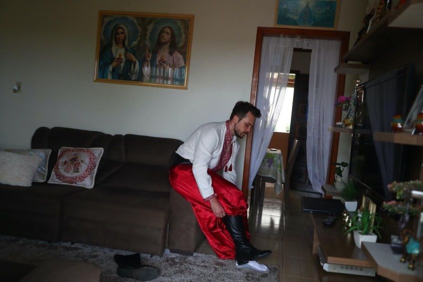 Rodrigo Michalovski veste-se no típico traje da "Irmandade dos Cossacos” / Pilar Olivares/Reuters (3.mar.2022)