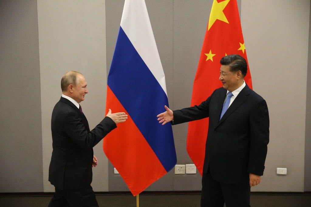 Presidente russo Vladimir Putin (E) cumprimenta o presidente chinês Xi Jinping (D) durante reunião em novembro de 2019