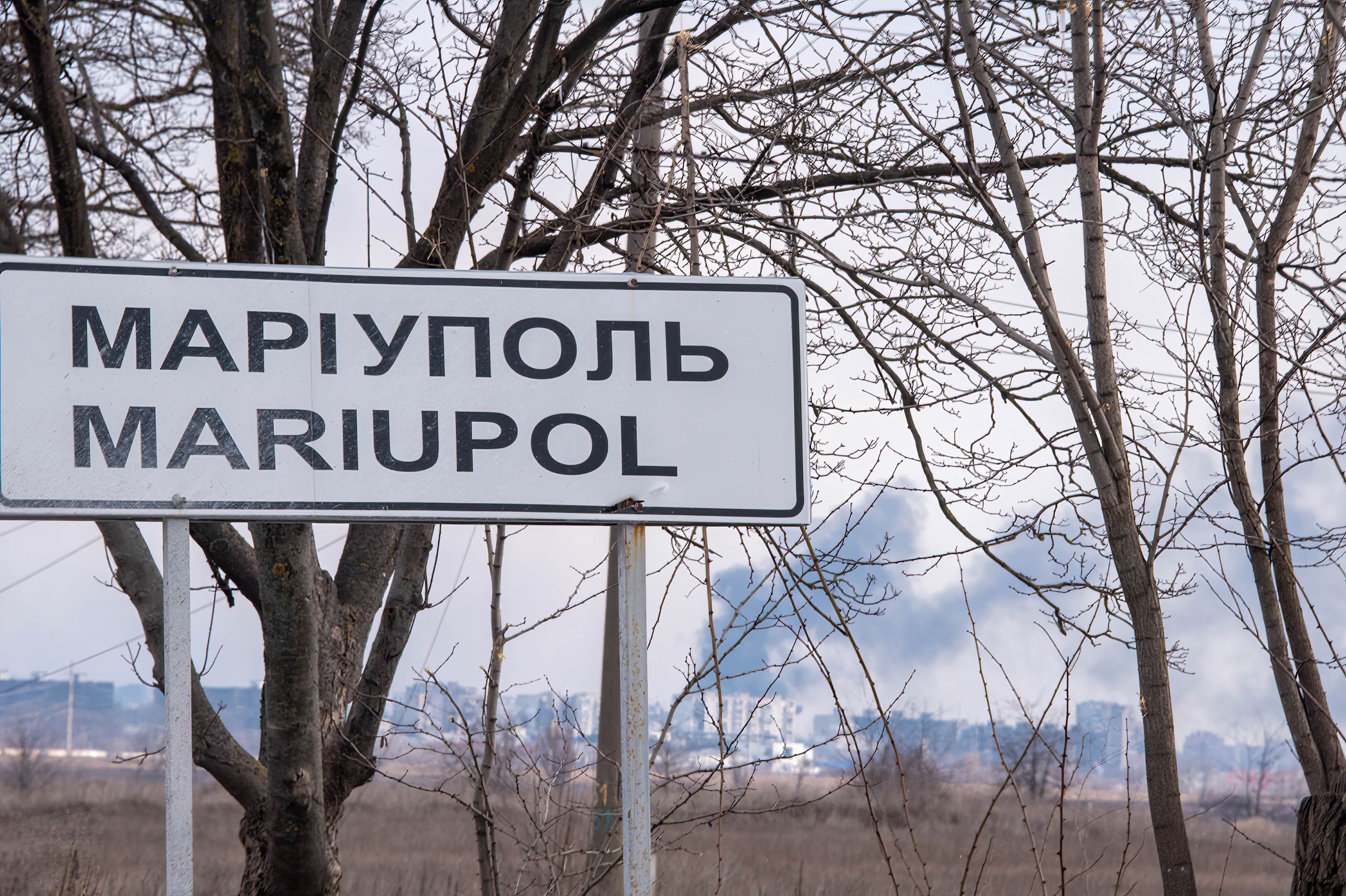 Smoke can be seen rising in the background from the sign at