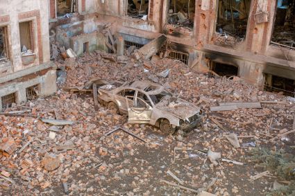 Carro destruído em meio aos escombros de uma universidade atingida por ataques russos em Kharkiv, na Ucrânia
