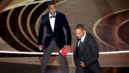Os atores Chris Rock e Will Smith no palco da cerimônia de premiação do Oscar 2022
