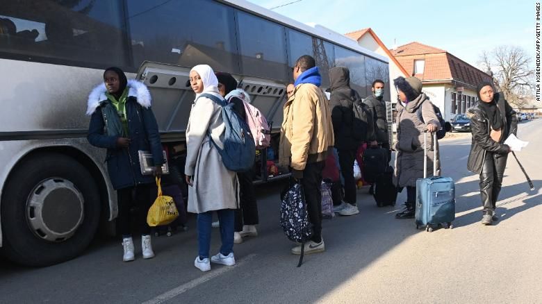 Estudantes universitários fugindo da capital Kiev, guardam sua bagagem enquanto entram em ônibus na fronteira entre Ucrânia e Hungria • AFP/Getty Images