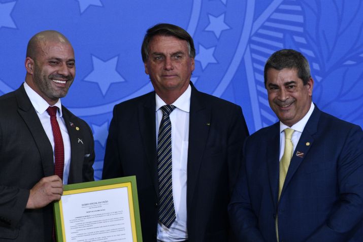 Bolsonaro acompanhado do deputado Daniel Silveira, segurando um quadro com quadro com decreto do presidente, e o deputado federal Coronel Tadeu (PL) em abril de 2022 / Foto: MATEUS BONOMI/AGIF/ESTADÃO CONTEÚDO
