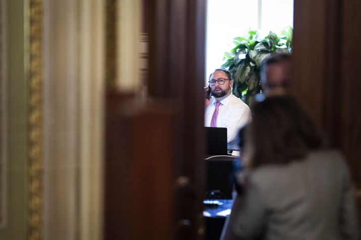 Jason Miller fala ao telefone em uma sala de reuniões para advogados do ex-presidente Donald Trump durante seu julgamento de impeachment no Senado no Capitólio, 12 de fevereiro de 2021 / Getty Images