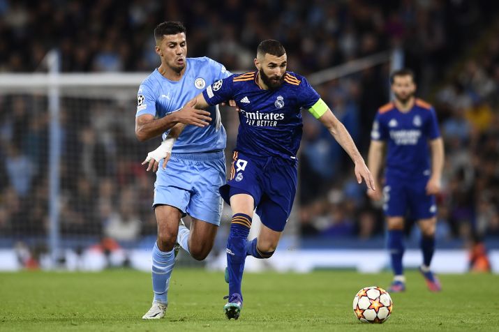 O volante Rodri, do Manchester City (à esq.), e o atacante Karim Benzema, do Real Madrid, disputam bola durante o primeiro jogo da semifinal da Champions League 2022 / Jose Hernandez/Anadolu Agency via Getty Images