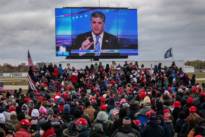 Apoiadores do presidente dos EUA, Donald Trump, assistem a um vídeo com o apresentador da Fox, Sean Hannity, antes da chegada de Trump a um comício de campanha em Michigan em 30 de outubro de 2020. / Getty Images